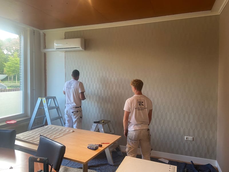 Two DEB experts installing the accent wallpaper